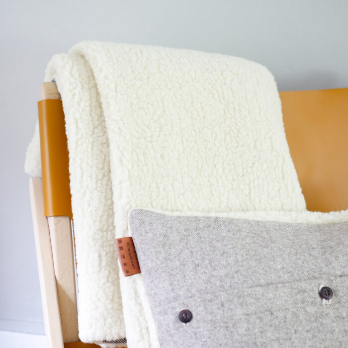 Coussin-fourrure-et-laine-pyloow-textile-ecoresponsable-plaid-couverture-cocooning-hiver-décoration-intérieure-nantes-textile-sur-fauteuil-cuir